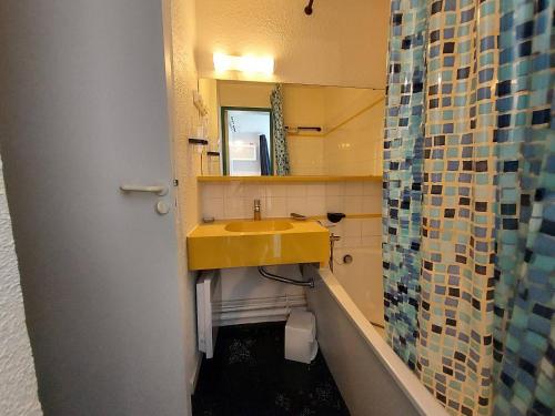 La salle de bains est pourvue d'un lavabo jaune et d'un miroir. dans l'établissement Charmant 2P à La Plagne, balcon sud, proche pistes et commerces, équipé pour 4 pers. - FR-1-353-119, à La Plagne Tarentaise