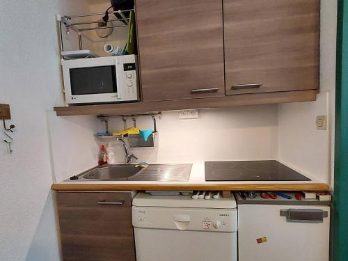 une petite cuisine avec un évier et un micro-ondes dans l'établissement Charmant 2P à La Plagne, balcon sud, proche pistes et commerces, équipé pour 4 pers. - FR-1-353-119, à La Plagne Tarentaise