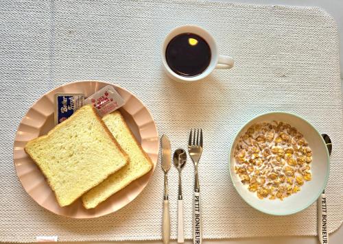 una mesa con un plato de tostadas y una taza de café en Incheon airport Guesthouse L, en Incheon