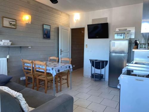 un salon avec une table et une cuisine dans l'établissement Beau T1 rénové proche Parc Charles de Gaulle avec wifi - FR-1-553-275, à Balaruc-les-Bains