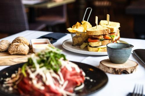 a table with two plates of sandwiches and chips at Marriott Hotel The Hague in The Hague