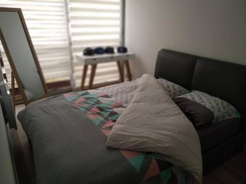 un lit assis dans une pièce avec une fenêtre dans l'établissement Appartement deux chambres au pied de la dune, à Lacanau