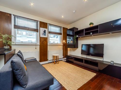 a living room with a couch and a flat screen tv at Museum Stay - Central London in London