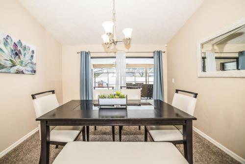 a dining room with a black table and white chairs at Zen Oasis - Royal Pool Paradise Near Tampa in Brandon