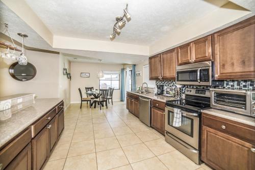a large kitchen with wooden cabinets and a dining room at Zen Oasis - Royal Pool Paradise Near Tampa in Brandon
