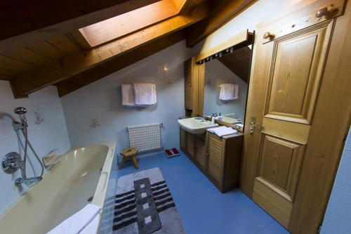 a bathroom with a tub and a sink at Villa Tamion in Vigo di Fassa