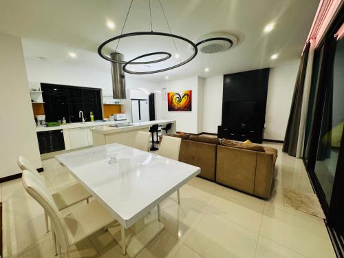 a living room with a white table and a couch at Sunrise Villa 21 in Phuket Town