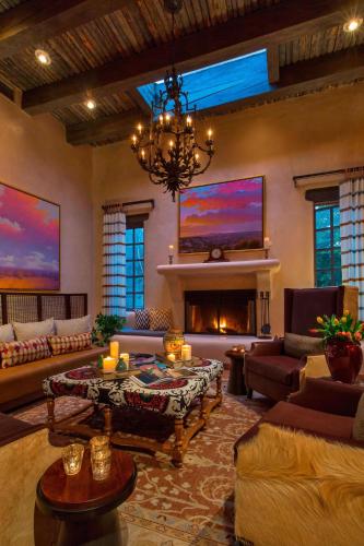 a large living room with a fireplace and a chandelier at La Posada De Santa Fe, a Tribute Portfolio Resort & Spa in Santa Fe