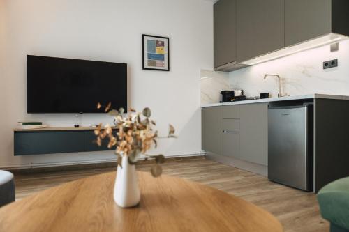 a kitchen with a vase with flowers on a table at Home Avenue in Alexandroupoli