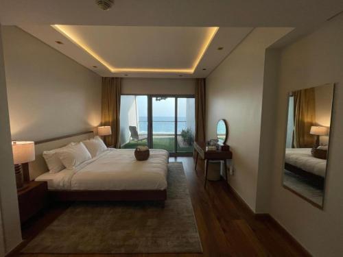 a bedroom with a large bed and a large window at Damac Tower Jeddah apartment in Jeddah