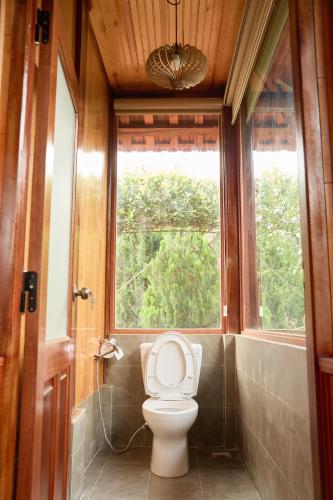 a bathroom with a toilet and a window at Gỗ Home in Ðinh An (2)