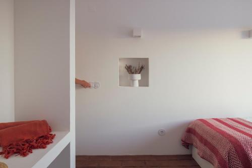 a bedroom with white walls and a bed at Vagar do Pastor in Alandroal