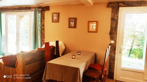 une salle à manger avec une table et un canapé dans l'établissement L'appartement du chalet, à Méolans