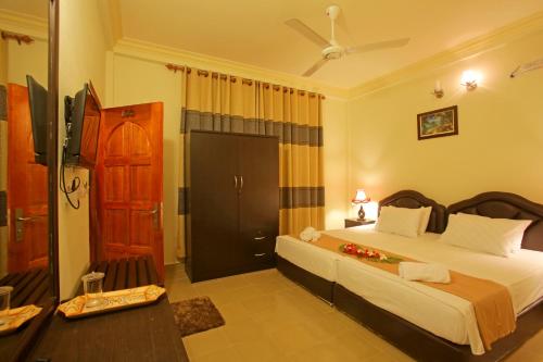 A bed or beds in a room at Hanifaru Transit Inn