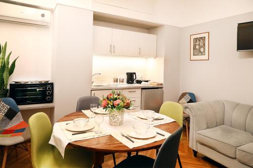 a living room with a table and a kitchen at My Athens House in Athens