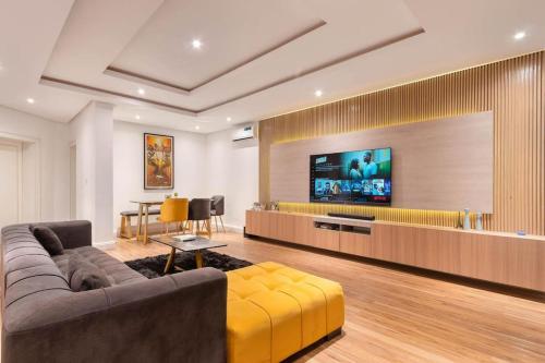 Una sala de estar con un sofá y un televisor de pantalla plana. en luxurious 4 bedroom duplex, en Lekki