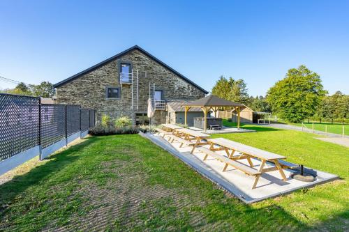 a group of picnic tables in front of a building at Au Frêne in Houffalize