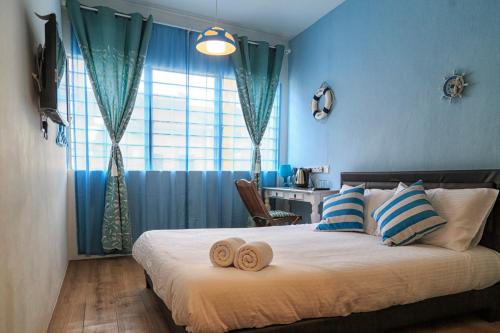 a bedroom with a bed with two towels on it at Elephant House Themed Hotel in George Town