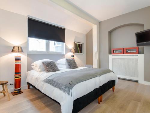 een slaapkamer met een groot bed en een groot raam bij Palm Apartment Amsterdam in Amsterdam