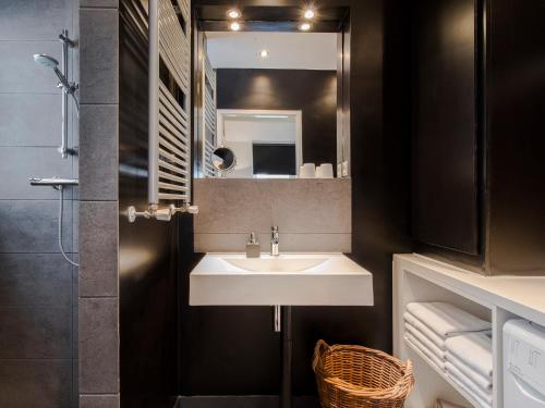 une salle de bain avec un lavabo et un miroir dans l'établissement Palm Apartment Amsterdam, à Amsterdam