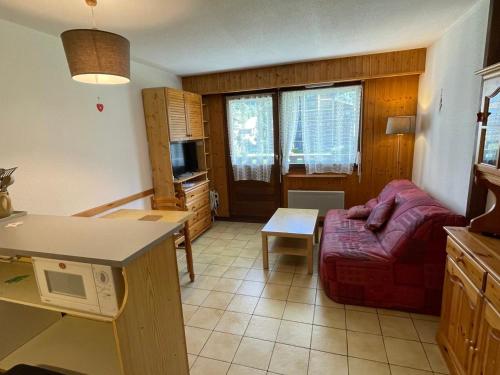 un salon avec un canapé rouge et une cuisine dans l'établissement Studio confortable avec balcon, pour 4 personnes à Samoëns - FR-1-629-117, à Samoëns