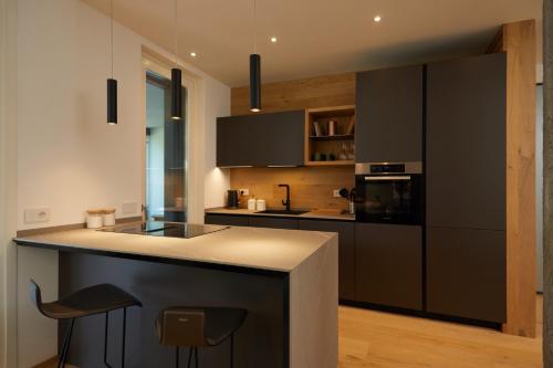 a kitchen with black cabinets and a counter top at The home by the river in Bellano