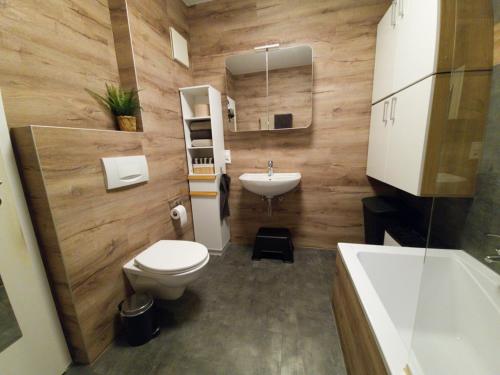 a bathroom with a toilet and a sink and a tub at Premium Apartment am Rande des Pfälzer Waldes in Ramstein-Miesenbach