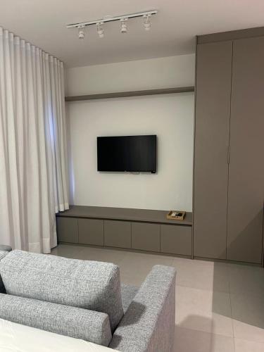 a living room with a couch and a flat screen tv at Blend Coliving AP 312 in Ribeirão Preto
