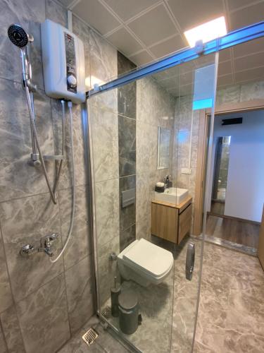 a bathroom with a shower with a toilet and a sink at Dalaman Çınar Apart in Dalaman