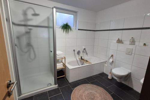 a bathroom with a shower and a tub and a toilet at Ferienwohnung AU in Bitburg in Bitburg