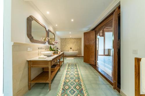 a bathroom with two sinks and two mirrors at Umah Lusa in Munduk