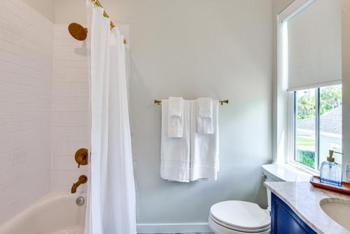 a bathroom with a white shower curtain and a toilet at 1 Mi to Riverwalk Brand New Bradenton Home in Bradenton