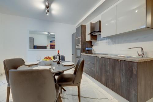 a kitchen and dining room with a table and chairs at Chic Apartment Stays in Il-Gżira