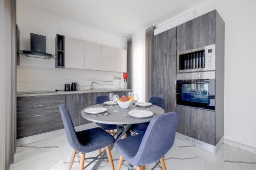 a kitchen with a table and blue chairs in a kitchen at Chic Apartment Stays in Il-Gżira