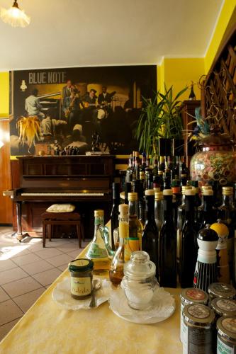 a counter with many bottles of wine and a piano at Altavilla Locanda E Tipica Trattoria in Bianzone