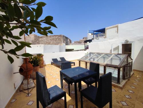 a patio with chairs and a table on a building at Riad de charme L'Oasis d'Essaouira - Chambre Luxe en Terrasse in Essaouira