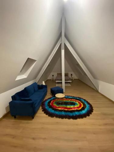 - un salon avec un canapé bleu et un tapis coloré dans l'établissement Appartement tranquille, à Luttenbach-près-Munster