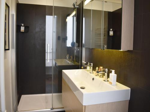 une salle de bain avec un lavabo blanc et une douche dans l'établissement Boulevard Pereire, à Paris