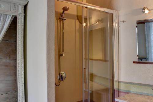 La salle de bains est pourvue d'une douche avec une porte en verre. dans l'établissement Dimora San Sebastiano, à Neive
