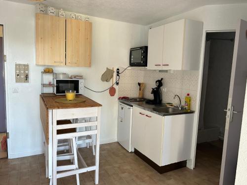 - une petite cuisine avec des placards blancs et un comptoir dans l'établissement Magnifique appartement grau du roi, au Grau-du-Roi