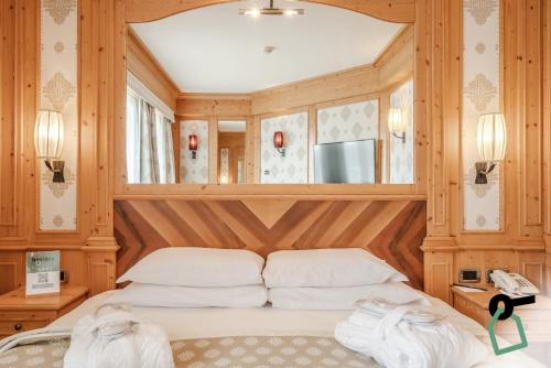 a bedroom with a bed with wooden walls at HOTIDAY Room Collection - Campiglio Pradalago in Madonna di Campiglio