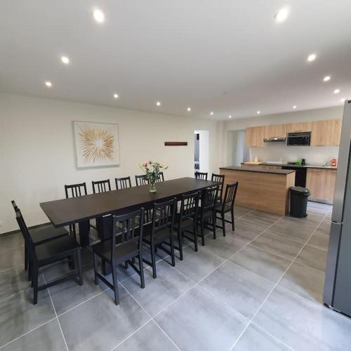 une salle à manger et une cuisine avec une table et des chaises dans l'établissement Maison des retrouvailles, à Bressolles