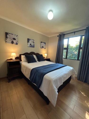 a bedroom with a large bed and a window at Khaled Estate Cottages - unit A in Hillcrest