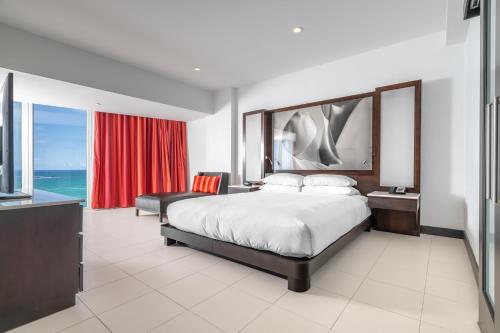 a bedroom with a large bed and a red curtain at The Condado Plaza Hotel in San Juan