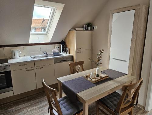 a kitchen with a wooden table and a dining room at Apartments am Storchenturm im Hellgrevenhof in Eisenach