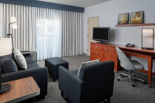 a hotel room with a desk and a tv at Courtyard by Marriott Dulles Airport Herndon/Reston in Herndon