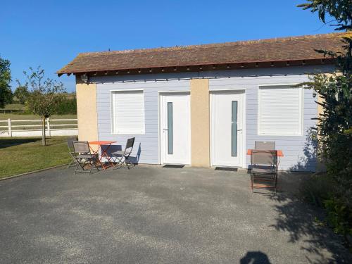Saint-Côme-de-FresnéにあるB&B de Saint Come de Fresnéの椅子とテーブルが前にある建物