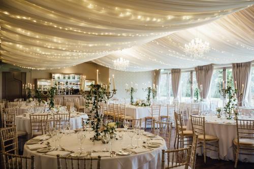 a room with tables and chairs with white tablecloths at Bellinter House Hotel & Spa in Navan