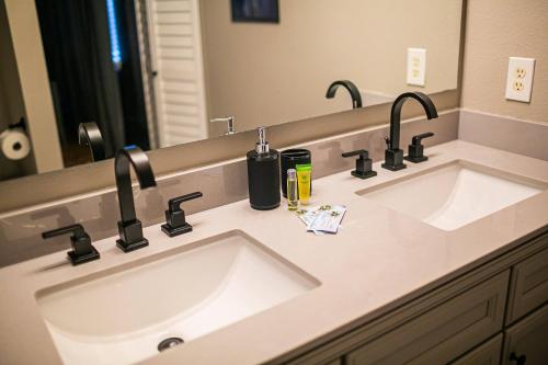 a bathroom with two sinks and two faucets at Thematic House with Private PoolSpaGame Room in Loughman