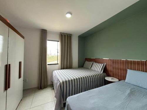 a hotel room with two beds and a window at Condomínio Indianopolis a 1,4km do North Shopping in Caruaru